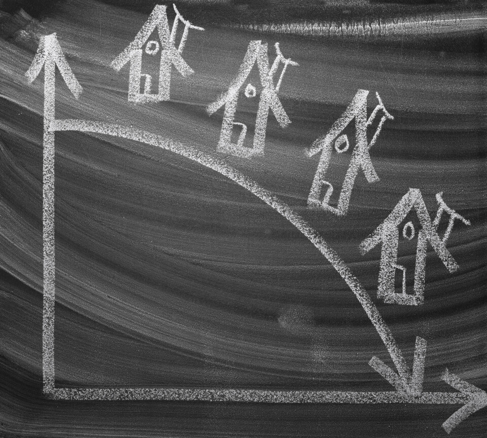 Det legges ned skoler og klasser i norske fylkeskommuner. Tegning på tavle av statistikk som peker nedover med bilde av flere hus.