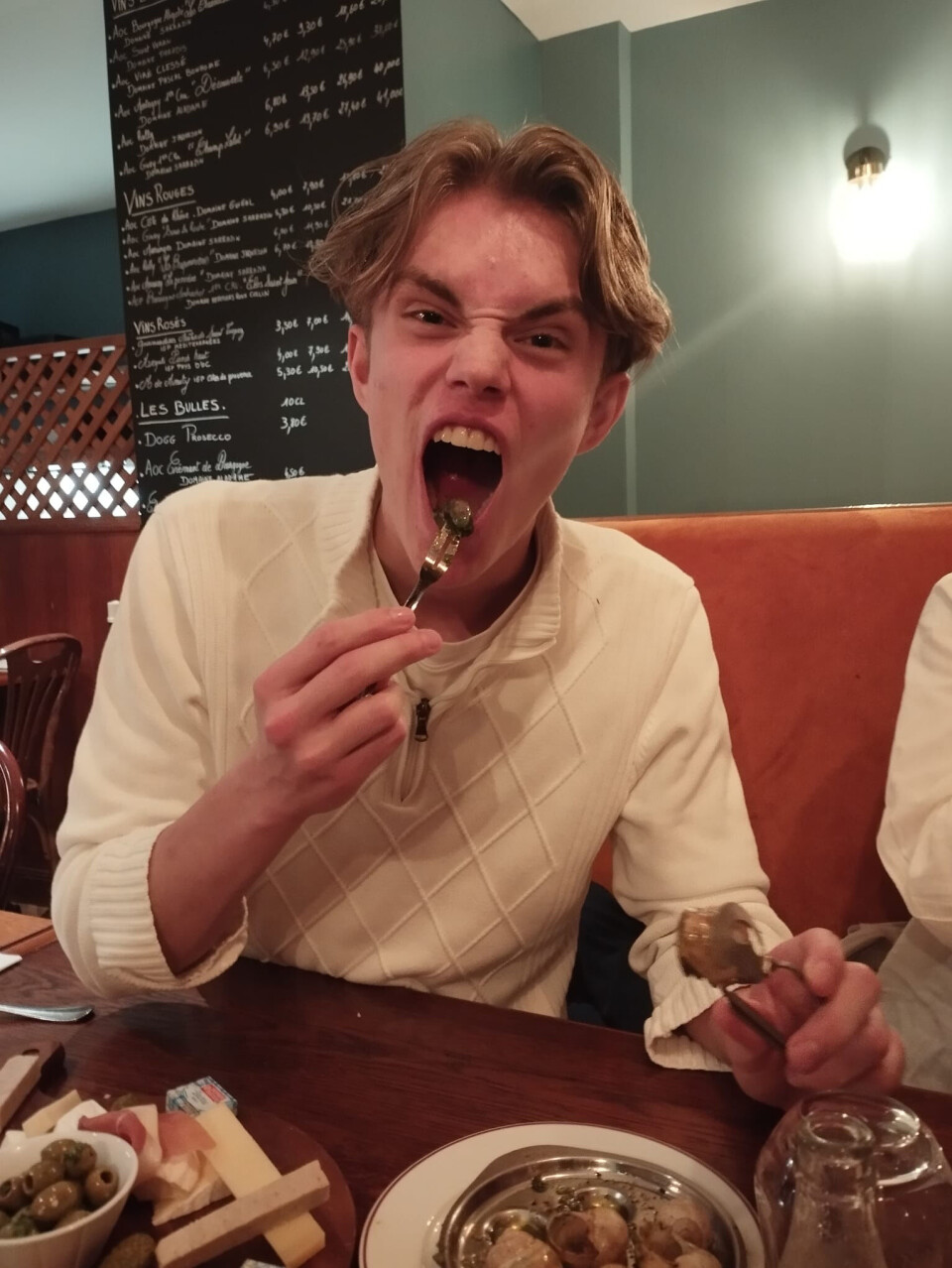 Flere av elevene prøvde seg på snegler. En ung gutt som smaker på snegler på fransk restaurant.